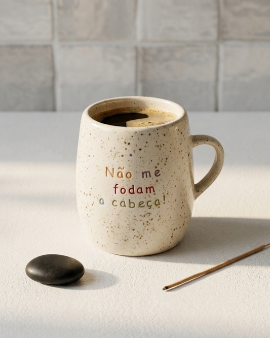 Caneca em cerâmica creme com salpicado castanho e frase gravada Não me fodam a cabeça em letras coloridas, Tia Cila