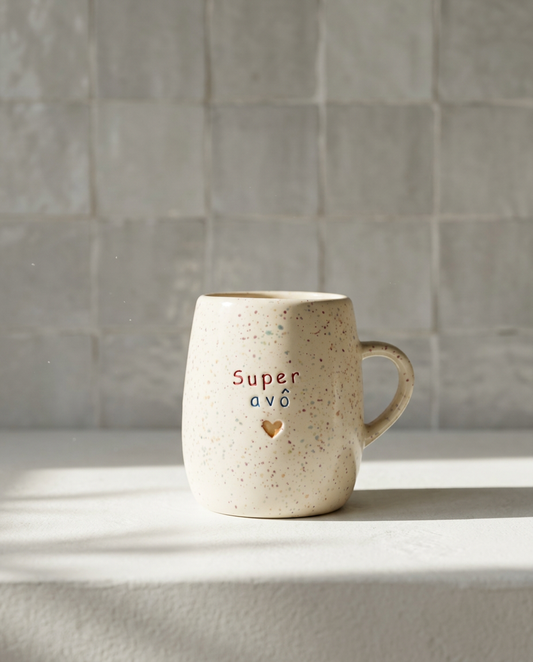 Caneca em cerâmica creme com salpicado multicolor e frase gravada Super avô em vermelho e azul com coração dourado, Tia Cila