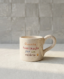 caneca de ceramica artesanal com pega salpicada com cores coloridas e a frase quanta humilhacao por um salario marca tia cila
