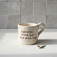 Caneca de cerâmica artesanal modelo Francisca, cor creme com salpicados ocre. Ao centro, a frase "Padrinho como pai, mas mais fixe!" gravada com um pequeno coração, fotografada com luz natural e uma colher pequena.