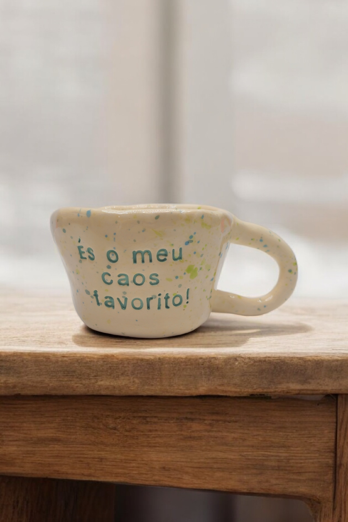 Caneca de cerâmica artesanal modelo Caetana com salpicado verde e frase gravada 'És o meu caos favorito' - Cerâmica Tia Cila.