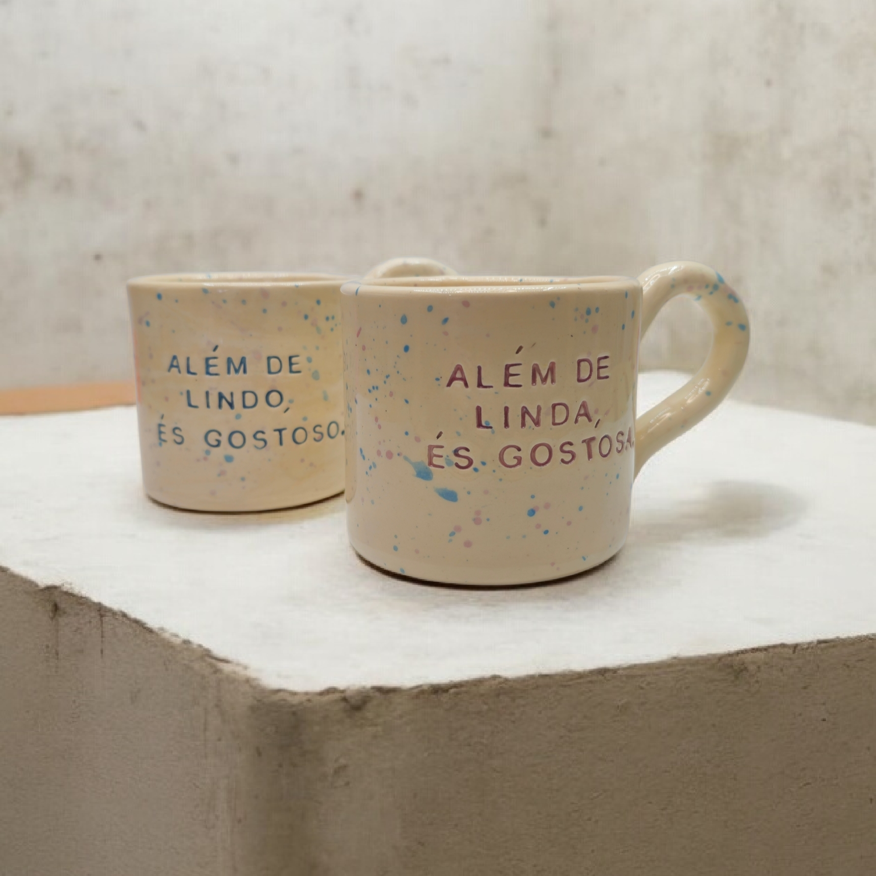 Conjunto de duas canecas de cerâmica artesanal modelo Francisca com salpicado multicolorido e frases divertidas 'Além de lindo, és gostoso' e 'Além de linda, és gostosa' – Cerâmica de autor Tia Cila