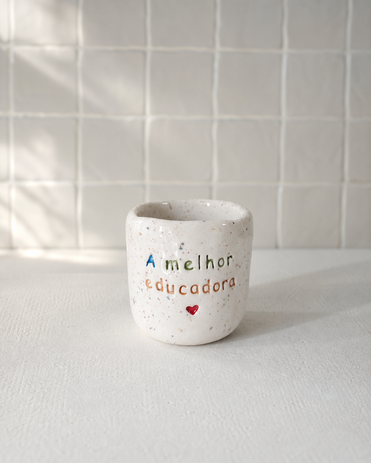 Copo Inês de cerâmica salpicada multicolorida com frase "A melhor educadora ♡" gravada à mão, Tia Cila