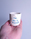 Copo de café pequeno em cerâmica artesanal com salpicado azul e a frase "Pai, és o maior!" gravada, modelo Inês da Tia Cila.