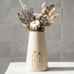 jarra grande de ceramica artesanal branca salpicada com cinco flores coloridas pintadas com nomes personalizados