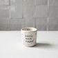 Copo de café em cerâmica artesanal branca com salpicado azul e a frase "Pai Herói sem capa" gravada à mão
